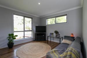 a living room with a couch and a tv at Riverside Haven in Healesville