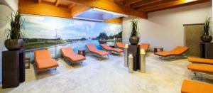 une salle d'attente avec des chaises orange et une grande fenêtre dans l'établissement ARAMIS Tagungs- und Sporthotel, à Gäufelden