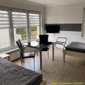 a bedroom with a desk with a laptop and a bed at Ferienwohnung Hagen in Hagen