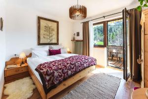 sypialnia z dużym łóżkiem i balkonem w obiekcie Das Halali - dein kleines Hotel an der Zugspitze w mieście Ehrwald