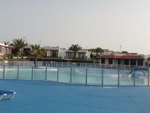 a swimming pool with a fence around it at Sun Luz Apartments 84 in Caleta De Fuste