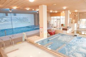 a large indoor swimming pool with a large tub at Kur and Hotel Isawa in Fuefuki