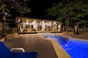 a resort with a swimming pool at night at Club Mahindra Netrang in Netrang