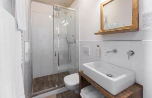 a bathroom with a shower and a sink and a toilet at Das Halali - dein kleines Hotel an der Zugspitze in Ehrwald +89 photos