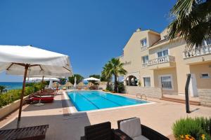 a villa with a swimming pool next to a building at Villa Kastel in Povljana