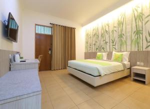 Hotel Huswah Airport في تانغيرانغ: غرفة نوم فيها سرير وتلفزيون