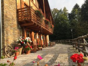 un edificio de ladrillo con flores y balcón en Agritur Dal Fior La Casa nel Bosco en Roncegno