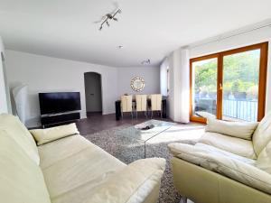 ein Wohnzimmer mit einem Sofa und einem TV in der Unterkunft Seeperle 3 in Meersburg