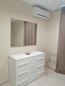 Vestidor blanco en una habitación con espejo en Attico Con Terrazza A Bari en Bari