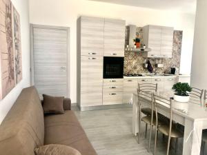 een keuken met een bank en een tafel met stoelen bij Casa Gio - Appartamenti Vacanze in Villaggio Azzurro