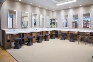 une salle d'attente avec une rangée de miroirs et de tabourets dans l'établissement Kur and Hotel Shinshu, à Shiojiri