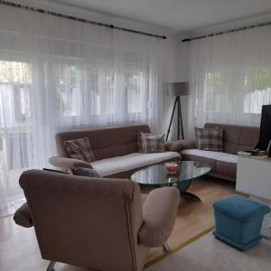 Vacation house Vila Guma Rastani Mostar في موستار: غرفة معيشة بها كنبتين وطاولة زجاجية