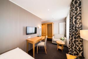 une chambre d'hôtel avec un bureau et une chambre dans l'établissement Landgasthof Redeker, à Haselünne