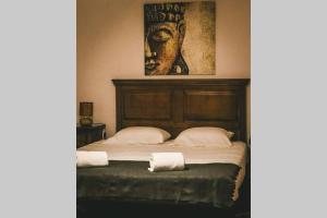 a bed with two pillows and a painting on the wall at Quinta do Pica-Pau Amarelo in Grândola +36 photos
