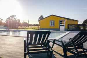 two chairs sitting on a deck next to a swimming pool at Quinta do Pica-Pau Amarelo in Grândola