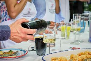 a person pouring a glass of wine on a table at Albergo Diffuso Bacco Furore in Furore