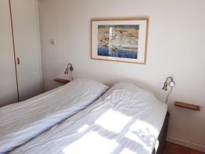 a bed in a room with a picture on the wall at Feriehus Nord på Rødkærgård in Kerteminde
