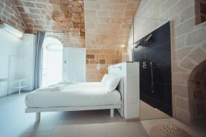 
a bedroom with a white bed and white walls at Endea Suite Rooms in Matera
