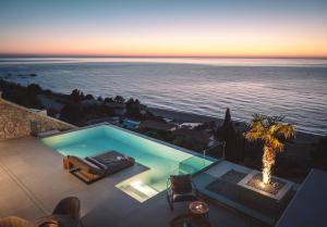 a swimming pool with a view of the ocean at THE WAVE TWIN VILLA 1 KATHISMA BEACH Lefkada in Lefkada