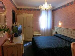 a bedroom with a blue bed and a television at Hotel Diana in Venice