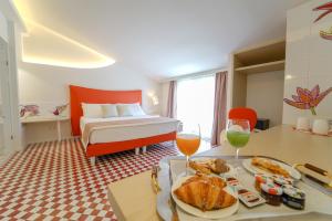 una habitación de hotel con una cama y una mesa con comida en Suite Hotel L'Oasi di Riaci en Santa Domenica