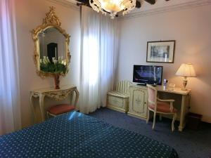 1 dormitorio con cama, espejo y TV en Hotel Diana, en Venecia