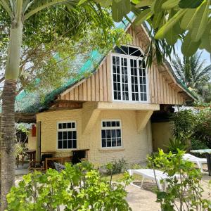 a house with a gambrel roof with a window at Victory Seaside Home in Bantayan Island