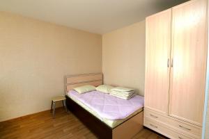 a small bedroom with a bed and a cabinet at Уютная квартира на Сибирской 44 in Novosibirsk