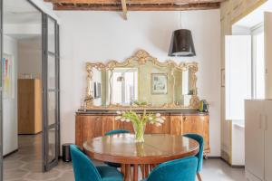 una sala da pranzo con tavolo in legno e sedie blu di iFlat Vatican High-End Apartment a Roma