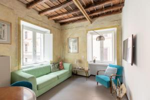 un soggiorno con divano verde e 2 finestre di iFlat Vatican High-End Apartment a Roma