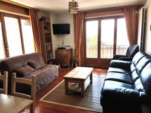 een woonkamer met een bank en een tafel bij Iris CONFORTABLE & PLEASANT apartments by Alpvision Résidences in Veysonnaz