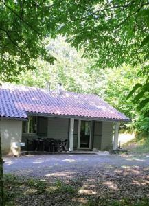uma pequena casa com um telhado roxo e um pátio em La Truite em Saint-Amans-Valtoret