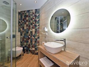 a bathroom with a sink and a mirror at Sabbia Apartments Seafront by TravelPro Services- Nea Moudania Halkidiki in Nea Moudania