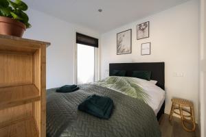 Un dormitorio con una cama con una manta verde. en Zonnelande - comfort studio, en Zoutelande