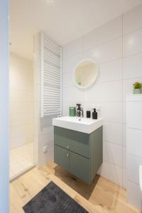 un baño con lavabo y espejo en Zonnelande - comfort studio, en Zoutelande