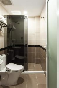 a bathroom with a toilet and a glass shower door at Central Studios at Ben Thanh Market by CIRCADIAN in Ho Chi Minh City +122 photos