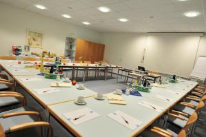 a classroom with rows of tables and chairs at AKZENT Hotel Stadt Schlüchtern ***S in Schlüchtern