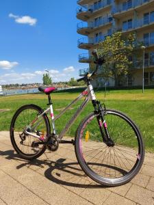 rower zaparkowany na chodniku obok budynku w obiekcie Bike & Spa Velence Apartman w mieście Velence
