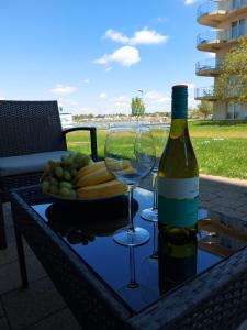 a bottle of wine and two glasses on a table at Bike & Spa Velence Apartman in Velence