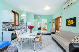 a kitchen and living room with a table and a couch at Villa Melina 2 in Koinyra