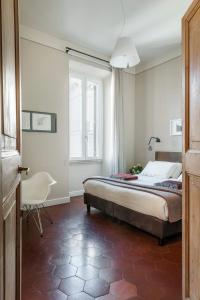 a bedroom with a bed and a chair and a window at MyNavona in Rome