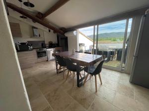 a kitchen with a table and chairs and a large window at Appartement de charme Sud Luberon classé 4 étoiles in Puyvert +7 photos