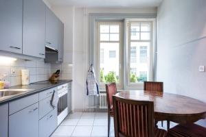 a kitchen with a table and chairs and a window at 2 Zimmer in Jugendstilwohnung mit Garten (1-6 P.) in Bern