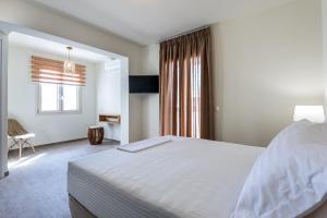 a bedroom with a large bed and a window at Remezzo Aqua Blue Maisonette in Livadi Astypalaias