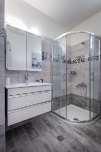a bathroom with a shower and a sink at Remezzo Aqua Blue Maisonette in Livadi Astypalaias