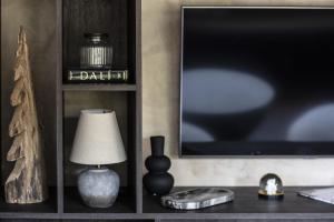 a living room with a tv and a table with a lamp at Apartment FERRONNE by JAPANDI home in Megève