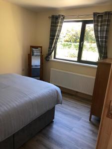 a bedroom with a bed and a large window at FOYLE VIEW CABIN in Greencastle