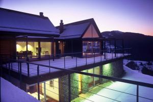 a house on the water with snow on it at Nebesa Chalets in Kobarid