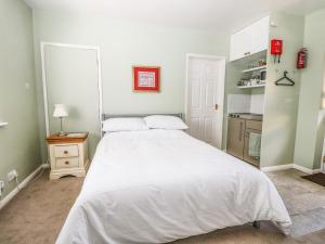 una camera con un grande letto bianco e una cucina di Karibu a Worthing