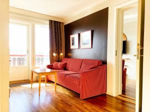 a living room with a red couch and a table at Savalen Fjellhotell & Spa in Tynset